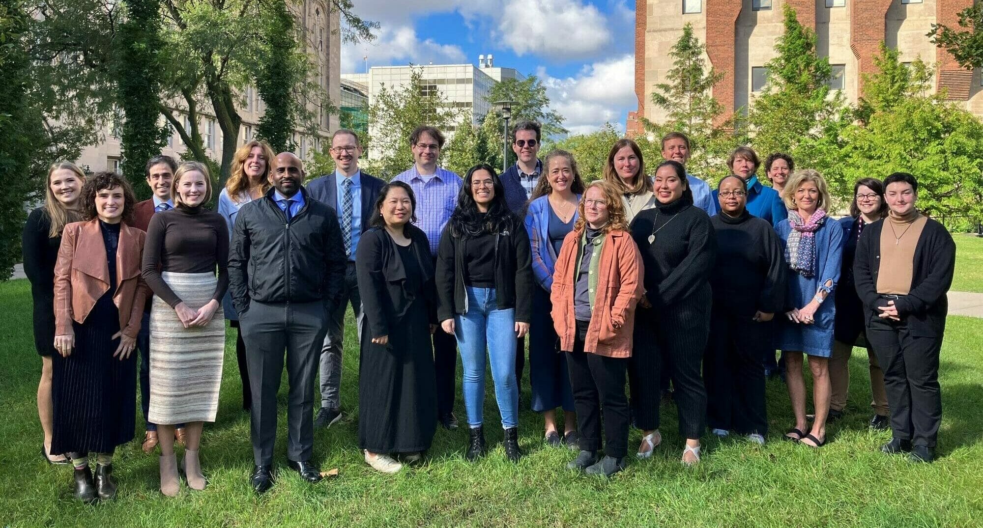 The UChicagoGRAD team gathers for a staff photo outside the bookstore on a sunny autumn day.